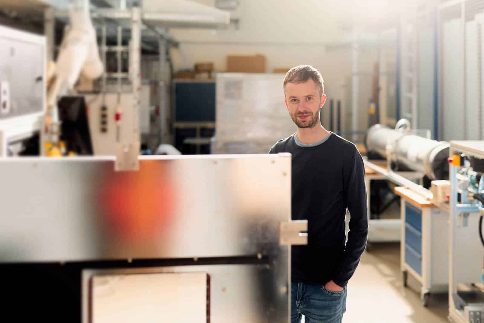 Patrick Obermark forscht mit der Rauchdichtemesskammer an adaptiver Lichttechnik f&uuml;r Not- und Sicherheitsbeleuchtung. Foto: P. Pollmeier/HSBI
